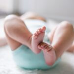 baby laying on back feet up